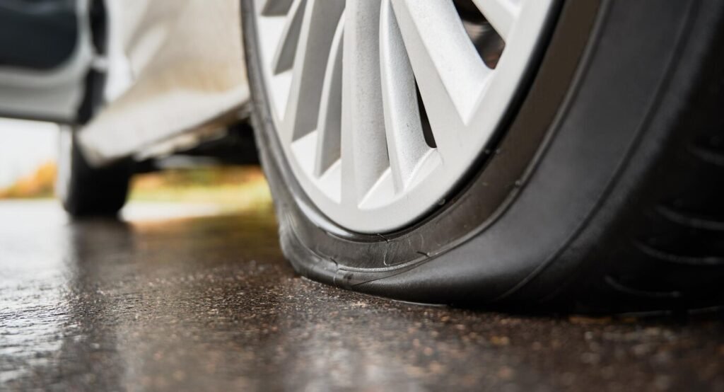 stopped-white-car-with-punctured-flat-tire-roadside_